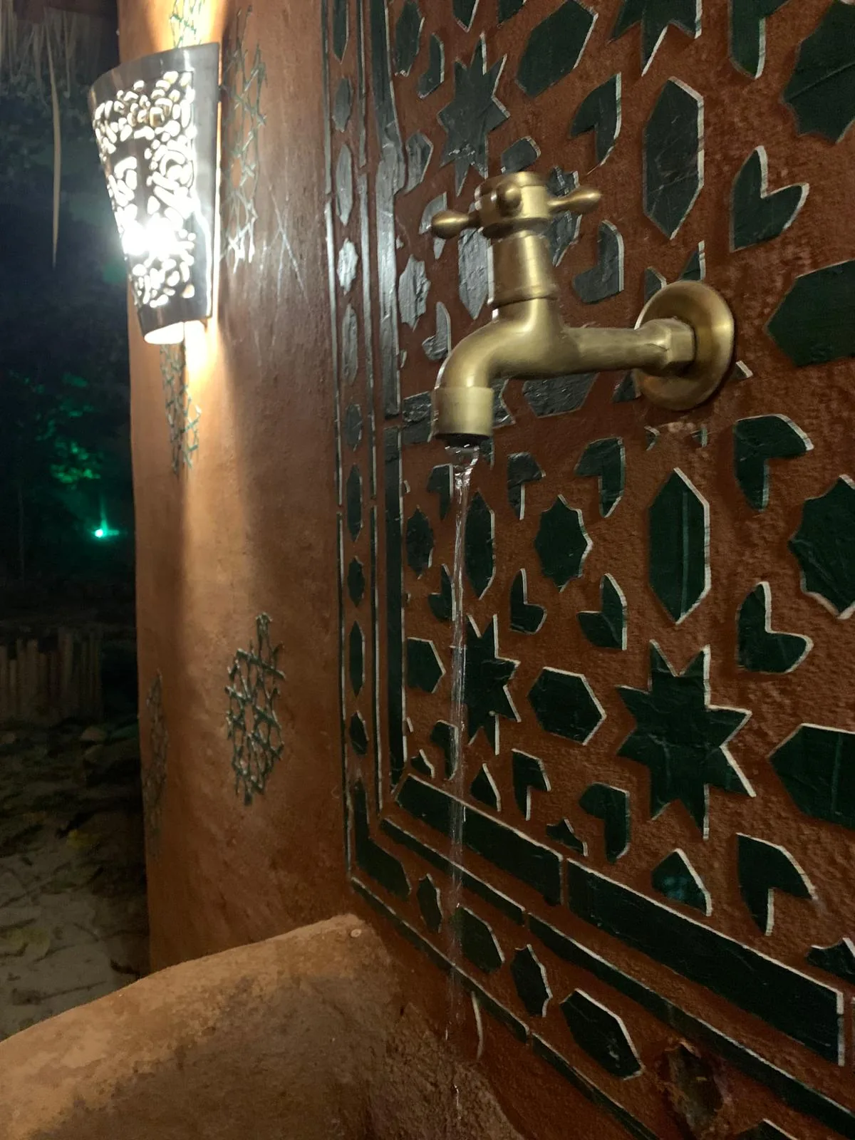 Brass tap on a green zellige fountain at Dar Mansour