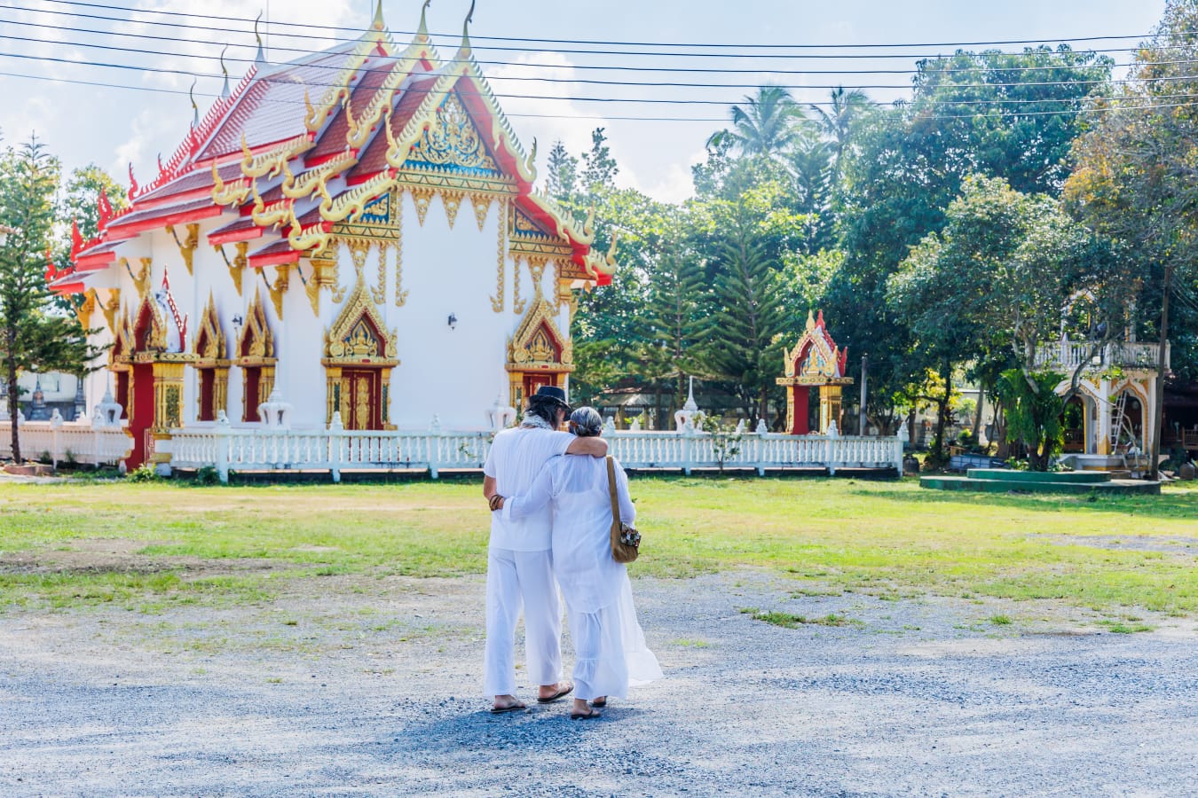 Maïja and Bruno, arm in arm before a Thai temple in Koh Phangan — the founders of Dar Mansour
