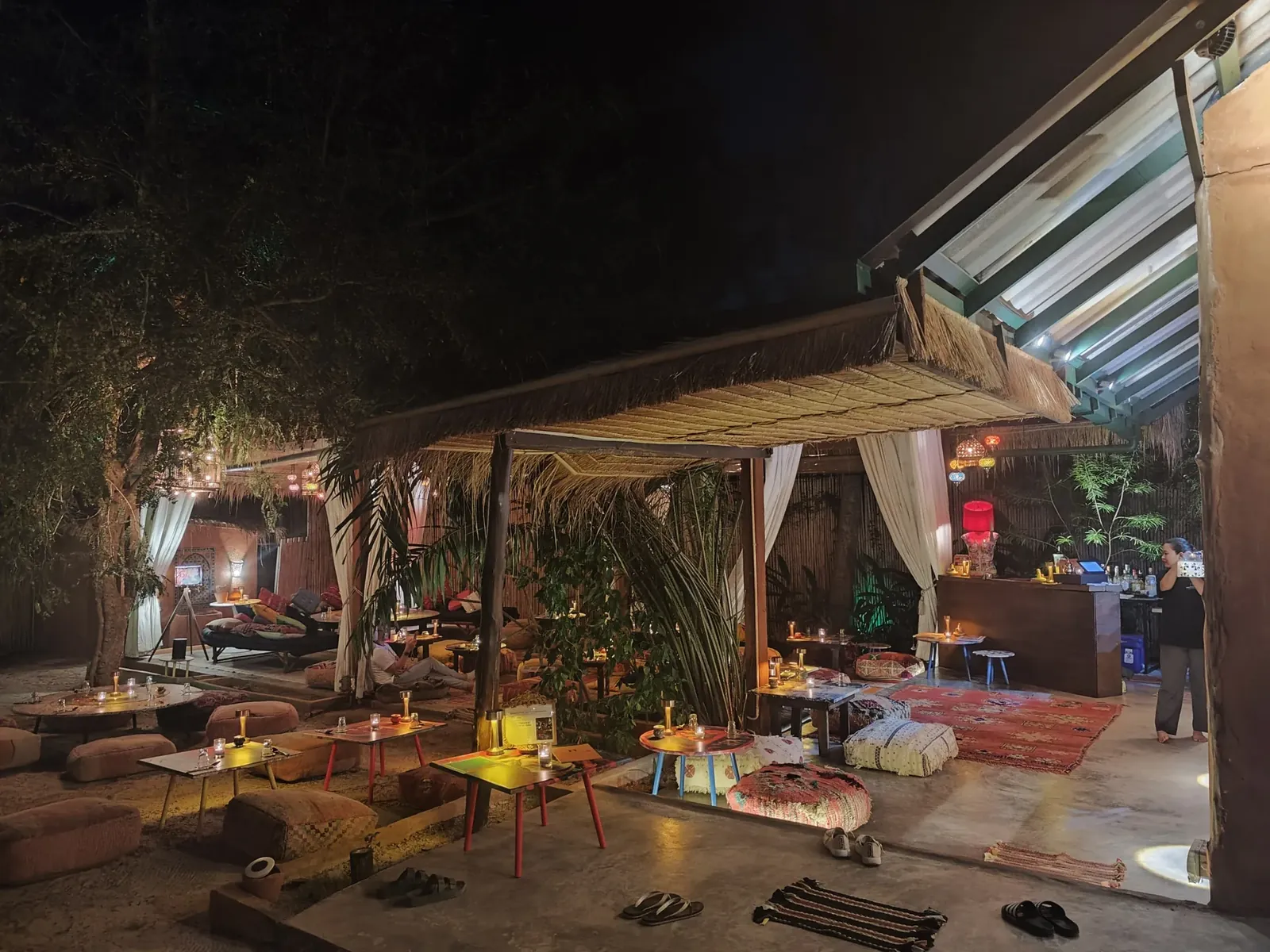 The candlelit garden lounge and illuminated Dar Mansour sign in Koh Phangan