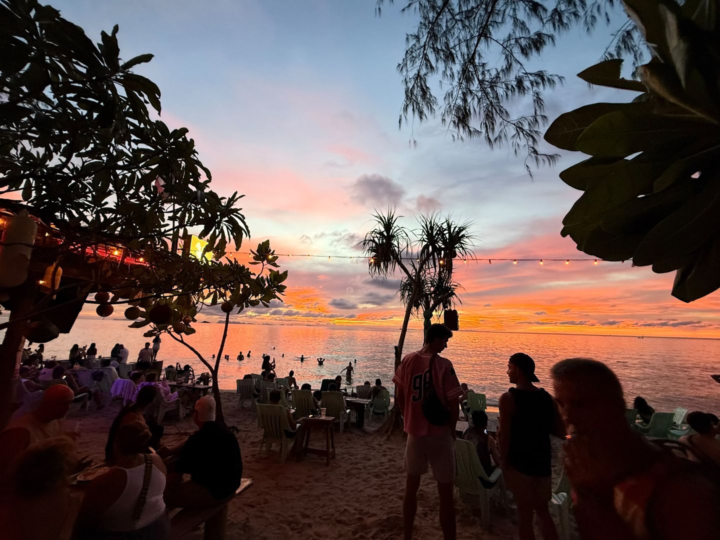 Beach tables and string lights at Grasshopper Beach Bar as the crowd gathers for sunset on Zen Beach, Sri Thanu, Koh Phangan