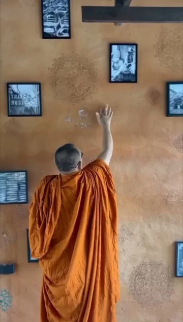 A Buddhist monk arranging artwork — the spirit of hospitality and cultural respect