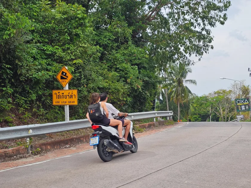 A steep road with a 'use low gear' sign, Koh Phangan Scooter riding on a steep road in Koh Phangan